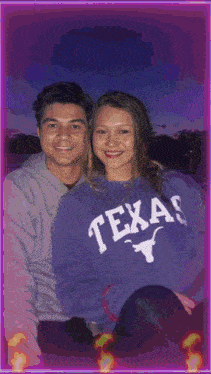 a man and a woman are posing for a photo and the woman is wearing a texas sweatshirt