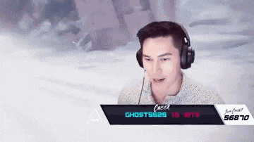 a man wearing headphones is playing a video game with ghosts25