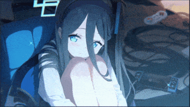 a blue haired anime girl is sitting on a couch next to a playstation controller
