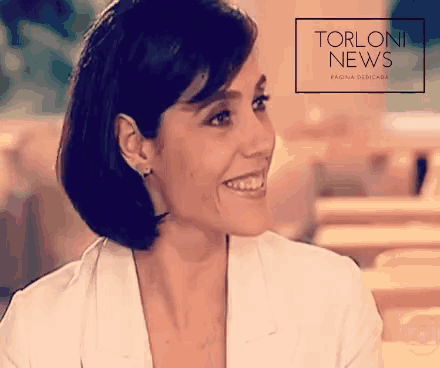 a woman is smiling in front of a torloni news banner
