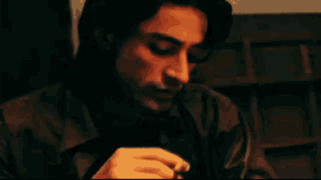 a man is smoking a cigarette and looking at the camera