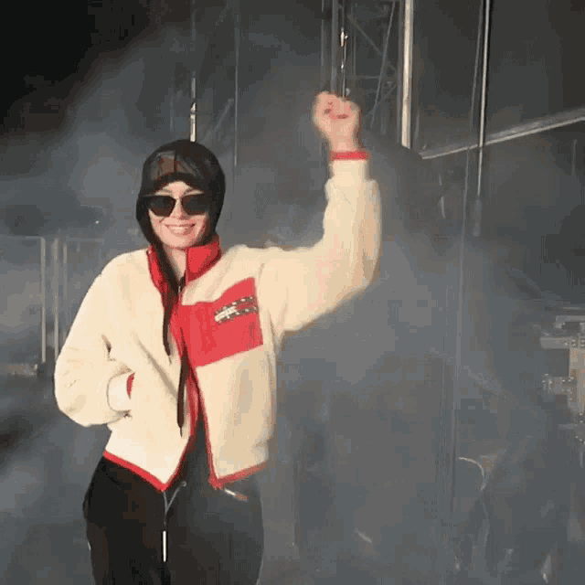 a woman wearing sunglasses and a jacket with a pocket that says ' lacoste ' on it