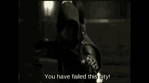 a man in a hooded costume is holding a bow and arrow and says `` you have failed this city '' .