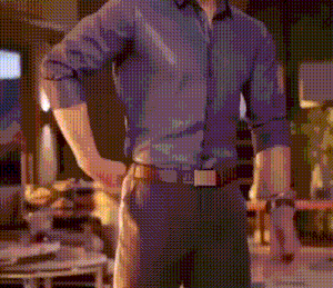 a man in a purple shirt and black pants is standing with his hands on his hips .