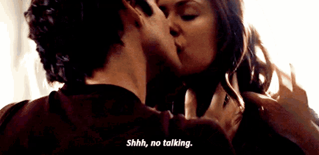 a man and woman are kissing and the woman is saying shhh no talking
