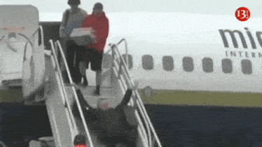 a man climbs the stairs of an airplane that says mit