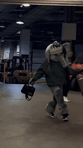 a person dressed in an elephant costume is holding a black purse