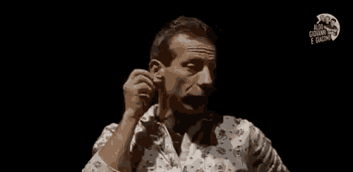 a man in a white shirt is making a funny face while holding his fist in the air .