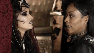 a couple of women are standing next to each other and looking at each other .