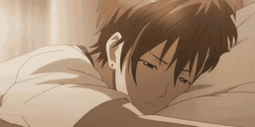 a man is laying on a bed with his head on a pillow and his eyes closed .