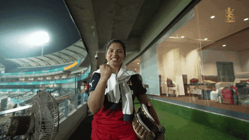 a woman with a towel around her neck is standing in a stadium