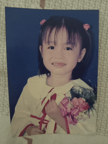 a picture of a little girl with a flower in her hair with the letter c on it