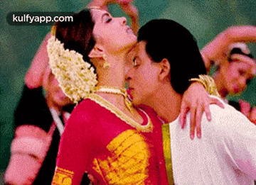 a man and a woman are kissing each other while dancing .