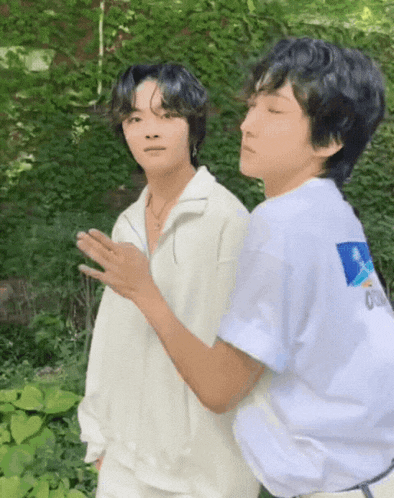 two young men standing next to each other with one wearing a white shirt that says ' 00 ' on it