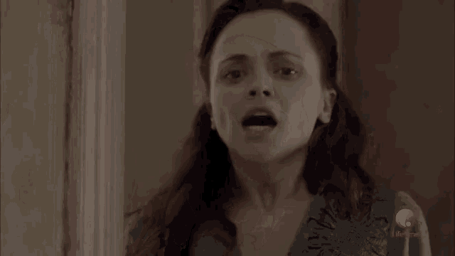 a woman is standing in a doorway with her mouth open and her eyes closed .