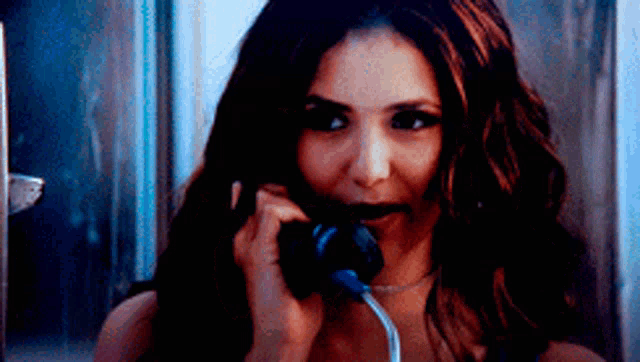 a woman with long hair is talking on a phone