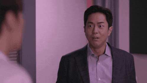 a man in a suit and a white shirt looks surprised