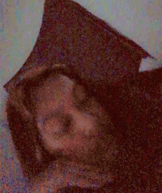 a woman is laying down with her eyes closed and her hand on her neck .