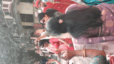 a woman with a flower in her hair stands in front of a crowd