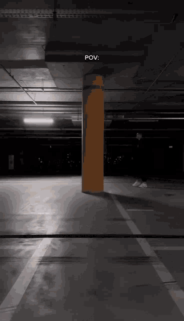 a yellow pole in a parking garage with the word pov written on the ceiling