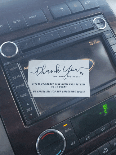 a car radio with a thank you for your business note on it