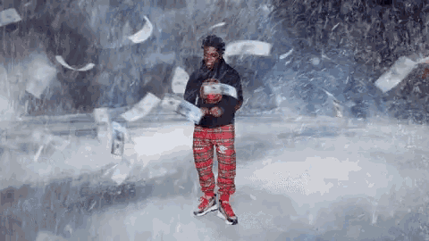 a man in plaid pants and a black hoodie is standing in the snow