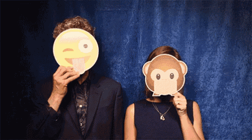a man and a woman covering their faces with monkey masks
