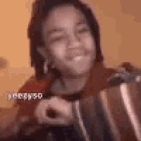 a girl with dreadlocks is smiling while holding a pot .