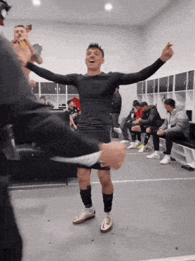 a man with his arms outstretched in a dressing room