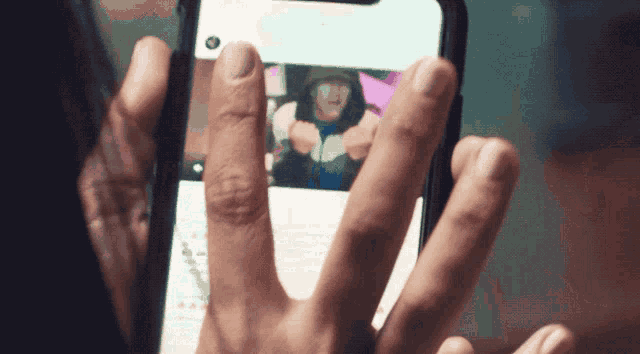 a person is holding a cell phone with a picture of a man on it