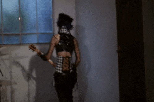a woman with purple hair is playing a guitar in a room