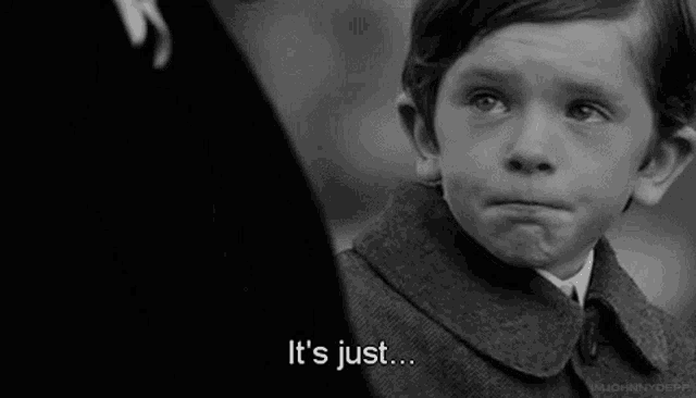 a black and white photo of a young boy making a sad face and saying `` it 's just '' .