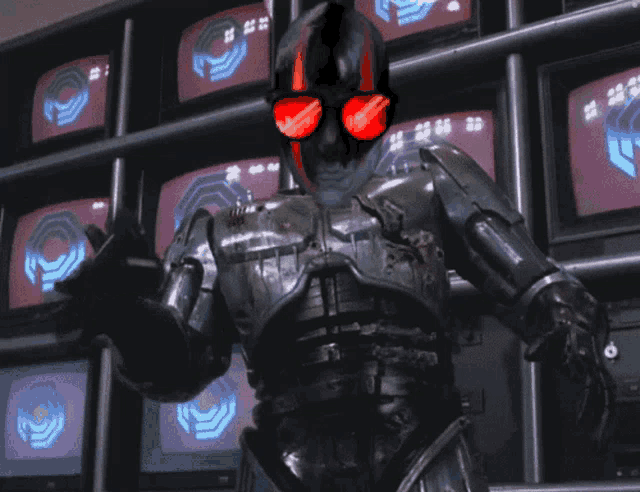 a robot wearing red sunglasses is standing in front of a wall of televisions