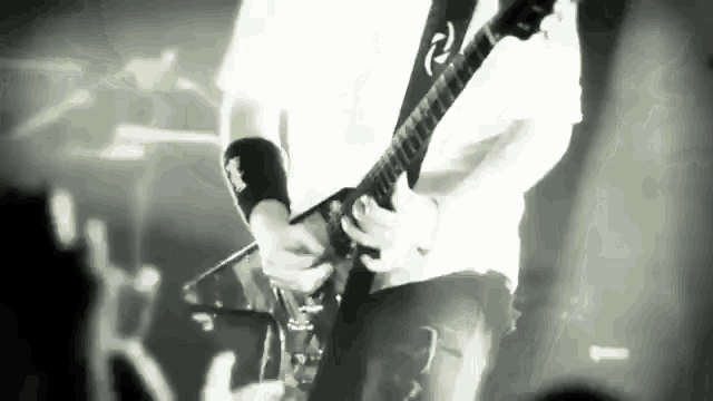 a man playing a guitar with the letter r on his wristband