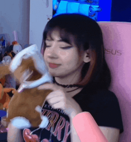 a girl is holding a stuffed animal and wearing a t-shirt that says ' sorry ' on it