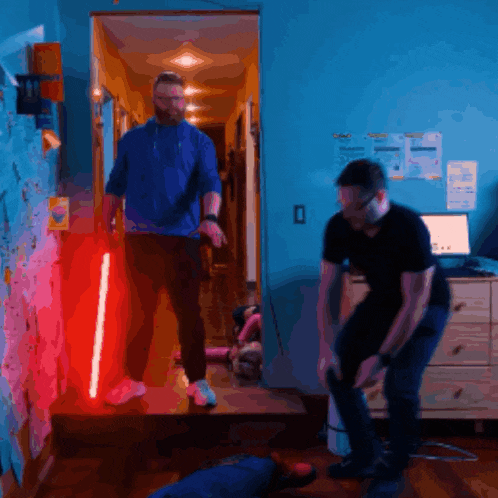 a man holding a red light saber in a room