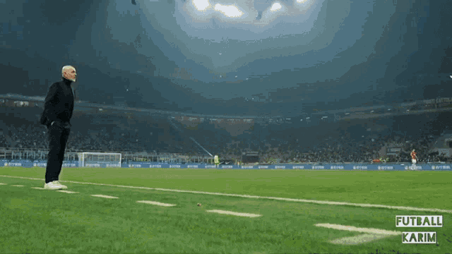 a man is running on a soccer field with the words futball karim on the bottom right