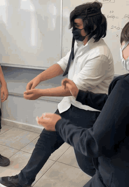 a man wearing a mask is kneeling next to another man