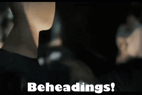 a man is sitting in a car with a paper bag on his head and the words beheadings written on the screen behind him .
