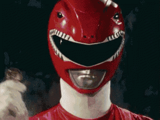 a close up of a red power ranger wearing a helmet and gloves .
