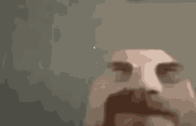 a close up of a man 's face with a beard and glasses