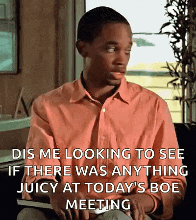 a man in an orange shirt is sitting in front of a window and says dis me looking to see if there was anything