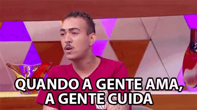 a man in a red shirt says " quando a gente ama "