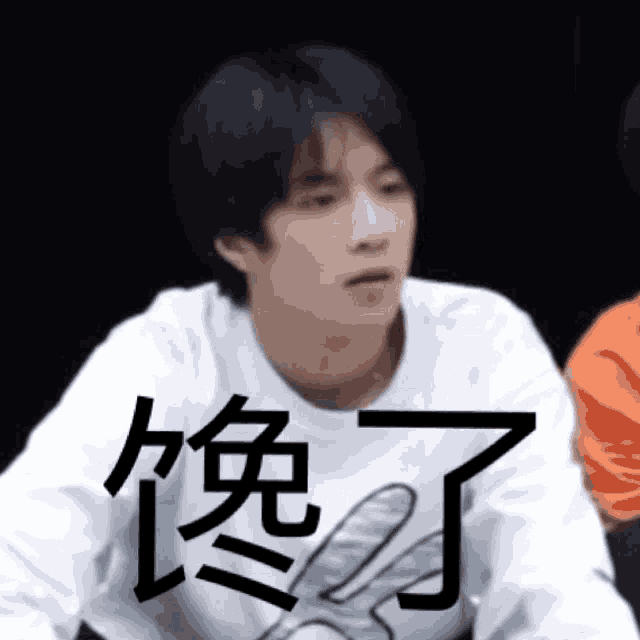a young man is wearing a white sweater with chinese writing on it