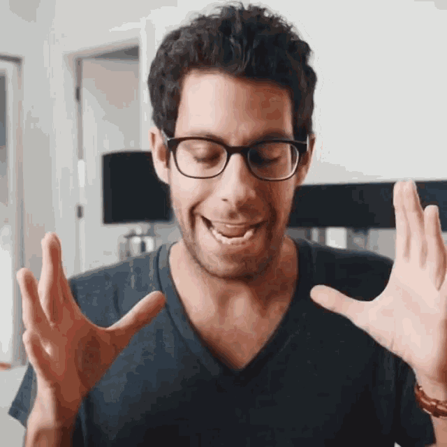 a man wearing glasses and a black shirt is making a face