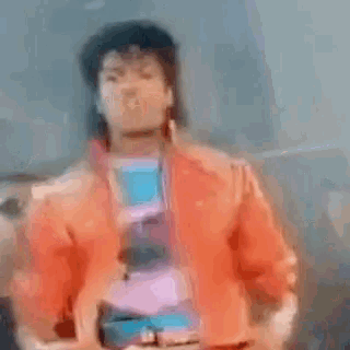 a blurry picture of a person wearing a red jacket and a blue shirt