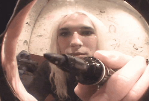 a woman with long blonde hair is holding a ring in her hand