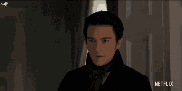 a man in a suit is standing in front of a door with netflix written on the bottom