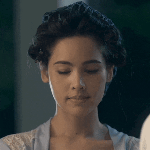 a woman with curlers in her hair is looking at herself in a mirror
