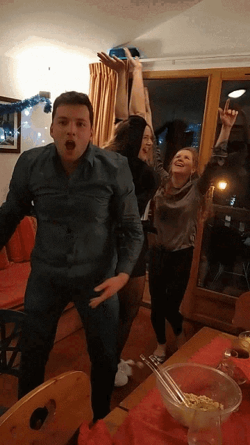 a group of people are dancing in a room with a bowl of cereal on the table